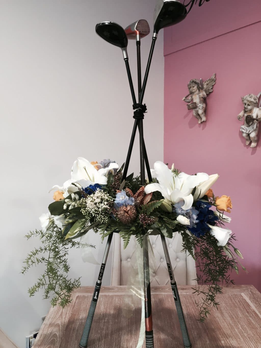 A Vase Filled with Golf Clubs and Flowers on A Table — Bundaberg House of Flowers in Bundaberg West, QLD