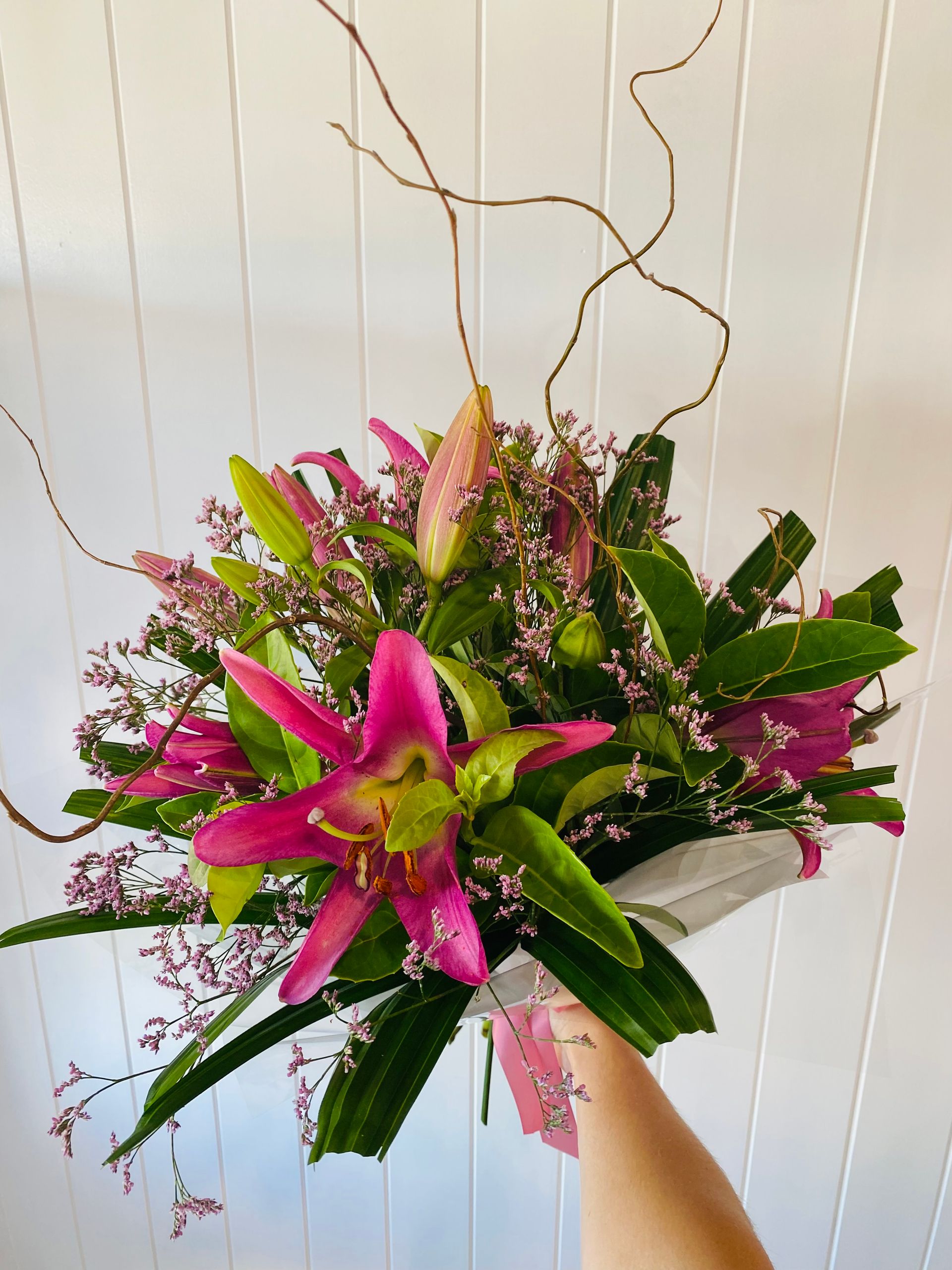 A Person is Holding a Bouquet of Pink and Green Flowers — Bundaberg House of Flowers in Bundaberg West, QLD