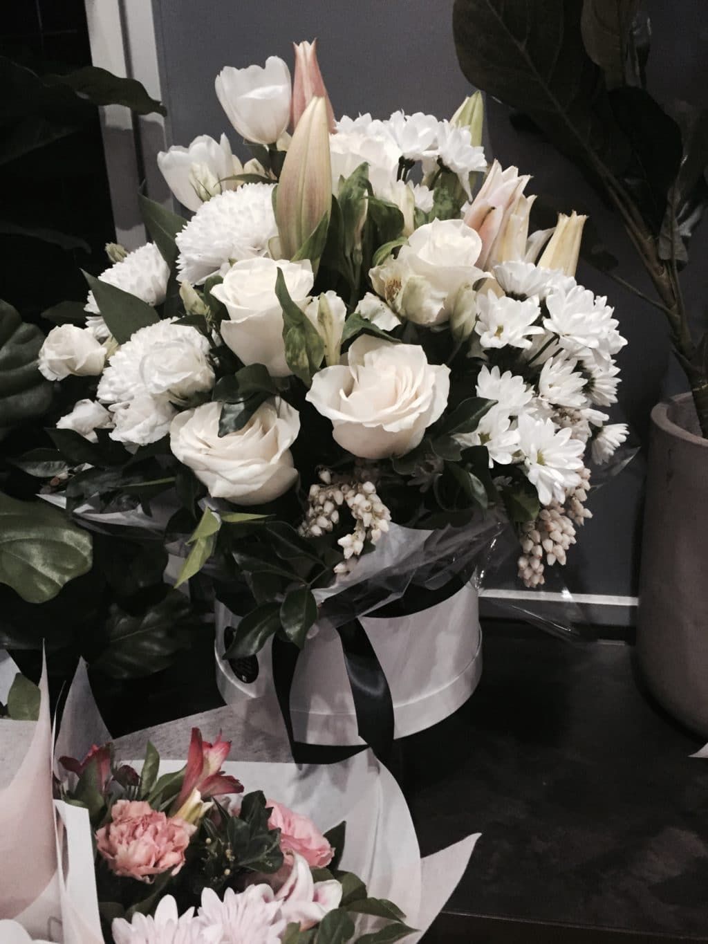 A Bouquet of White Flowers in A Box with A Black Ribbon — Bundaberg House of Flowers in Bundaberg West, QLD