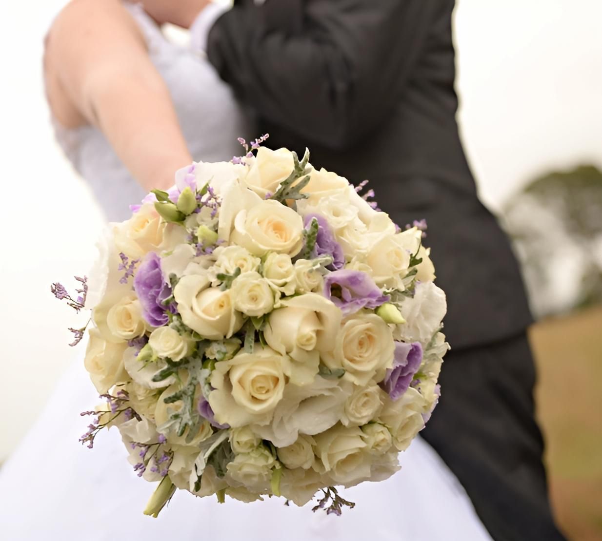 A Bride is Holding a Bouquet of Flowers — Bundaberg House of Flowers In Moore Park Beach, QLD