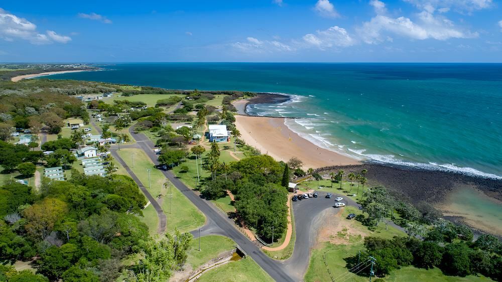 An Aerial View of a Beach With Trees and a Road Leading to It — Bundaberg House of Flowers In Burnett Heads, QLD