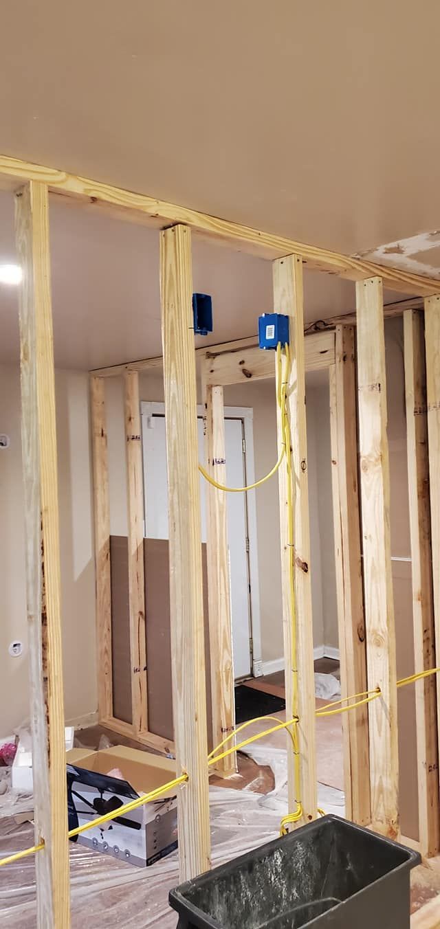 A room is being built with wooden beams and a bucket on the floor.