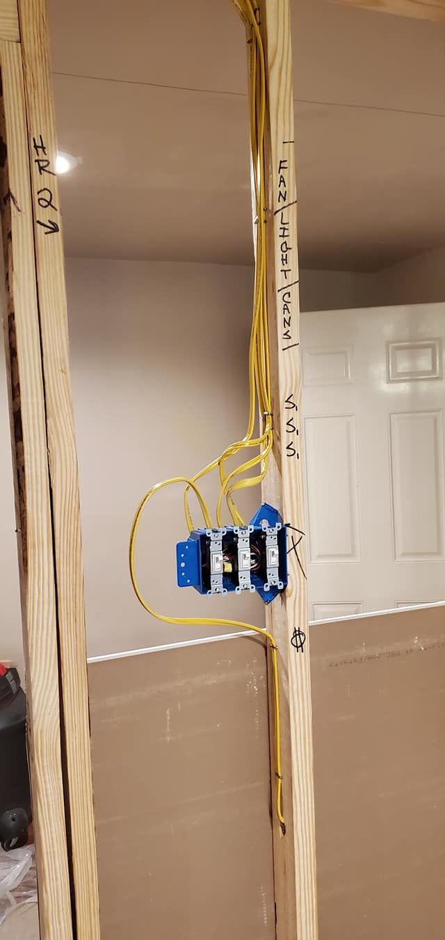 A wooden post with electrical wires coming out of it.