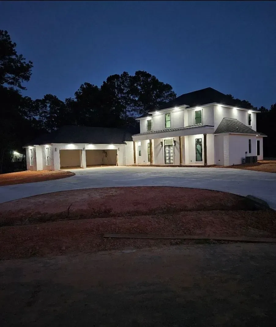 A large white house is lit up at night
