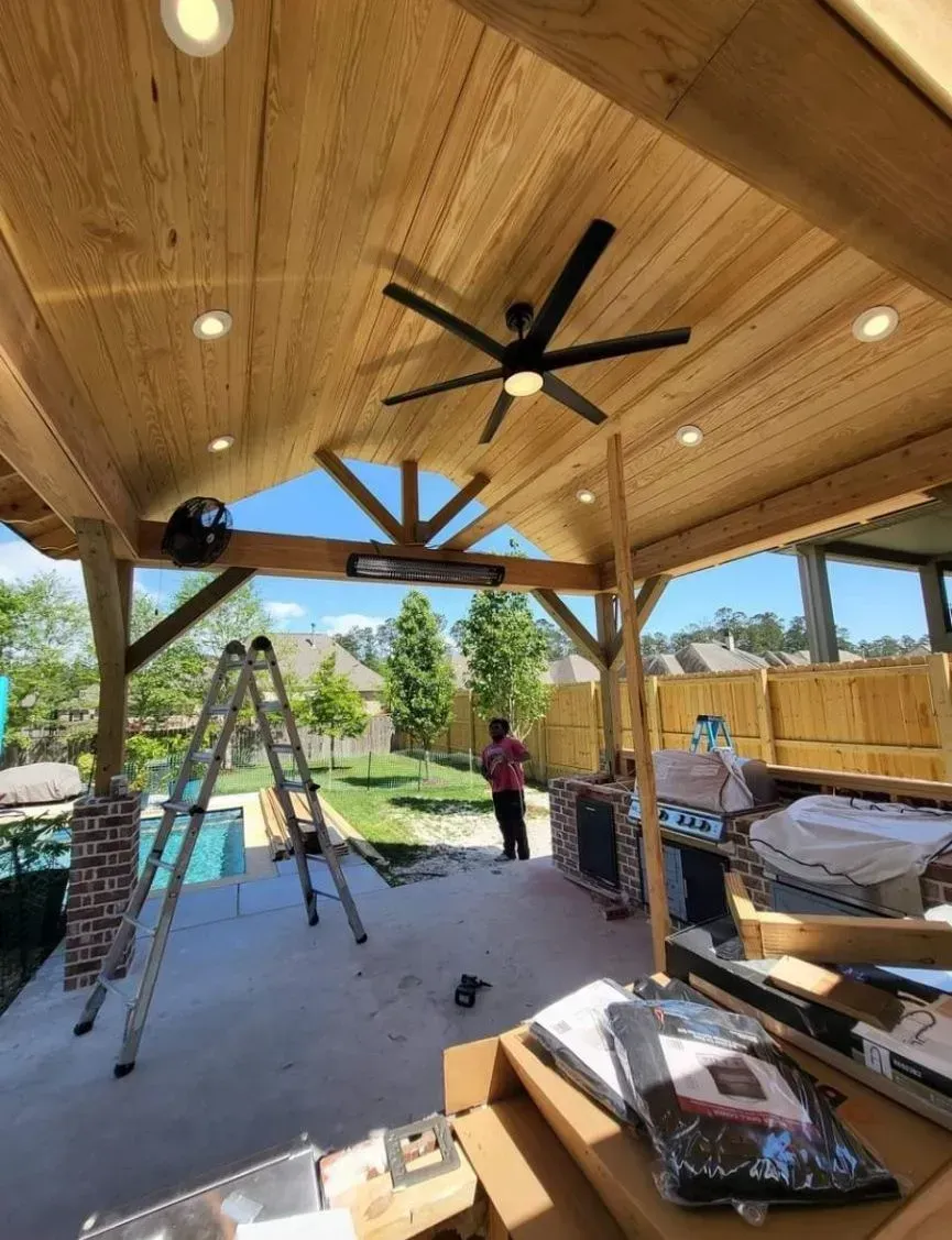 A ceiling fan is hanging from the ceiling of a wooden structure.