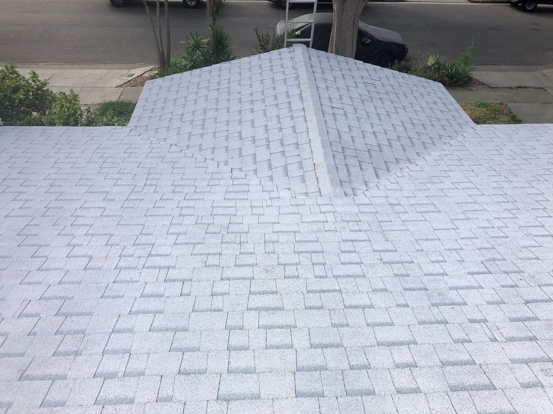 A white roof with a black car parked in the background