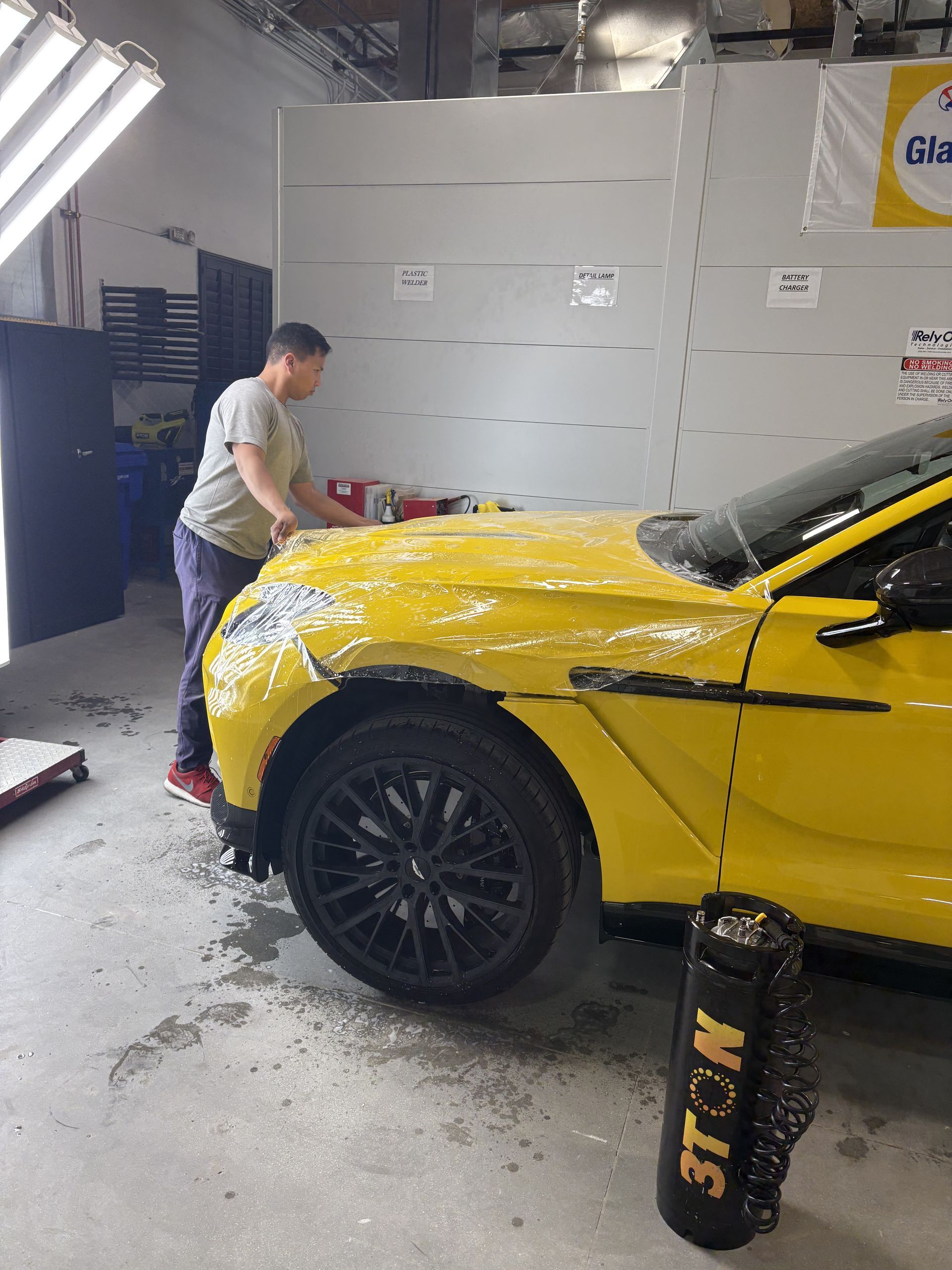 A man is cutting the side of a car with a welding machine.