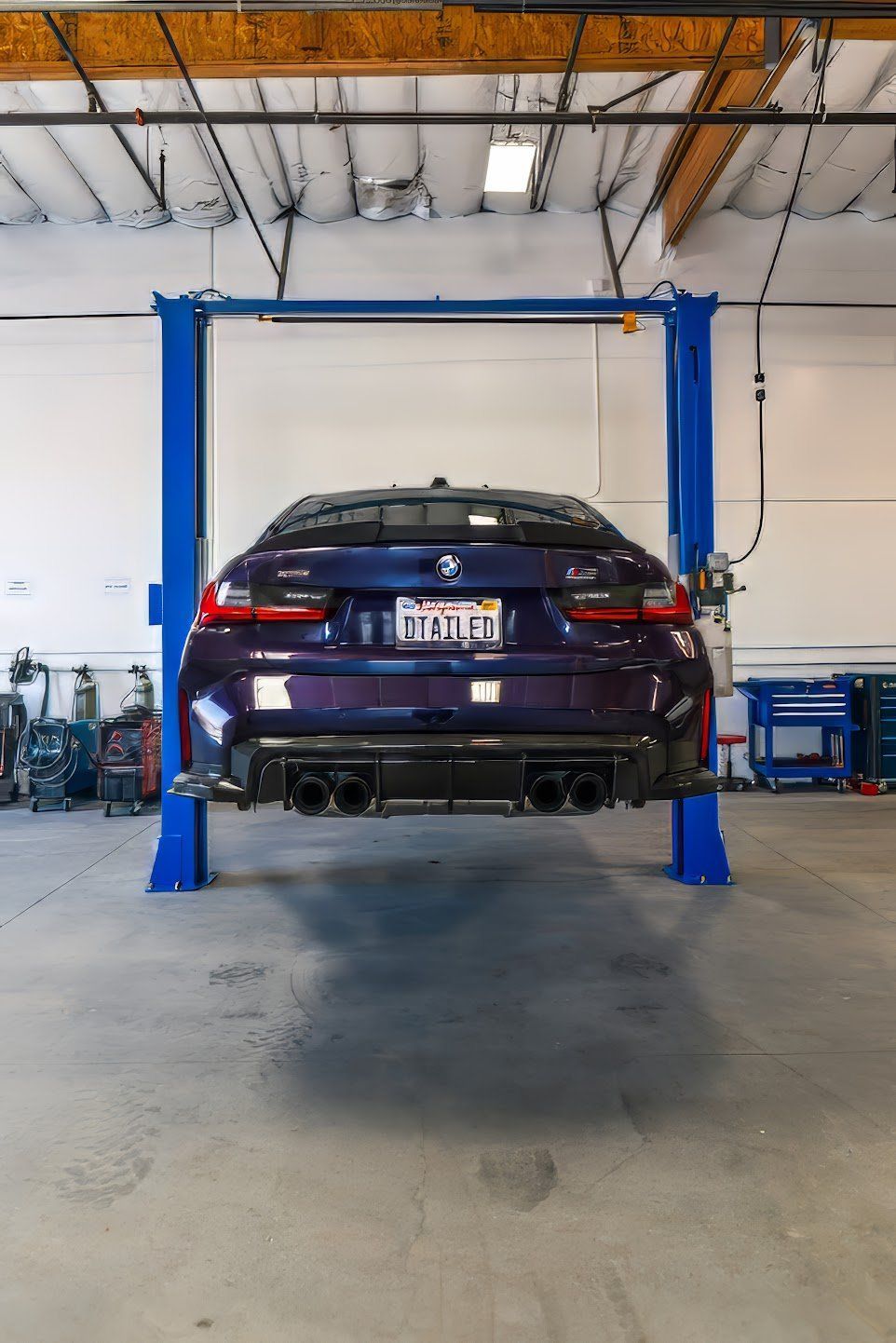 A man is working on the engine of a car in a garage.