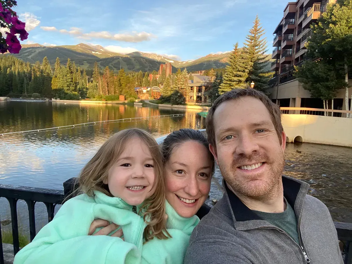 Attorney Andrew Smith and his family are posing for a picture in front of a lake.