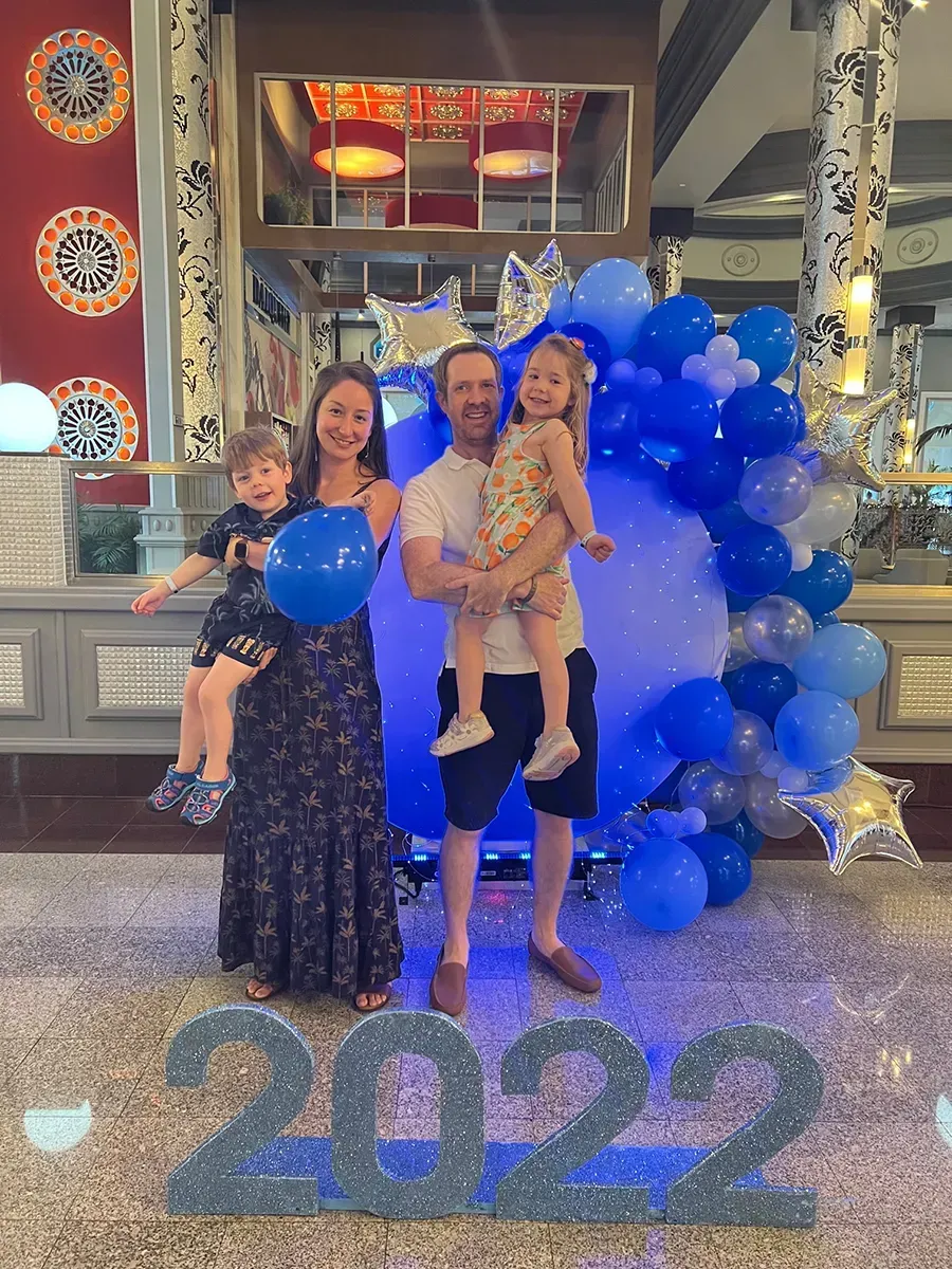 The family of Attorney Andrew Smith is posing for a picture in front of a sign that says 2022.