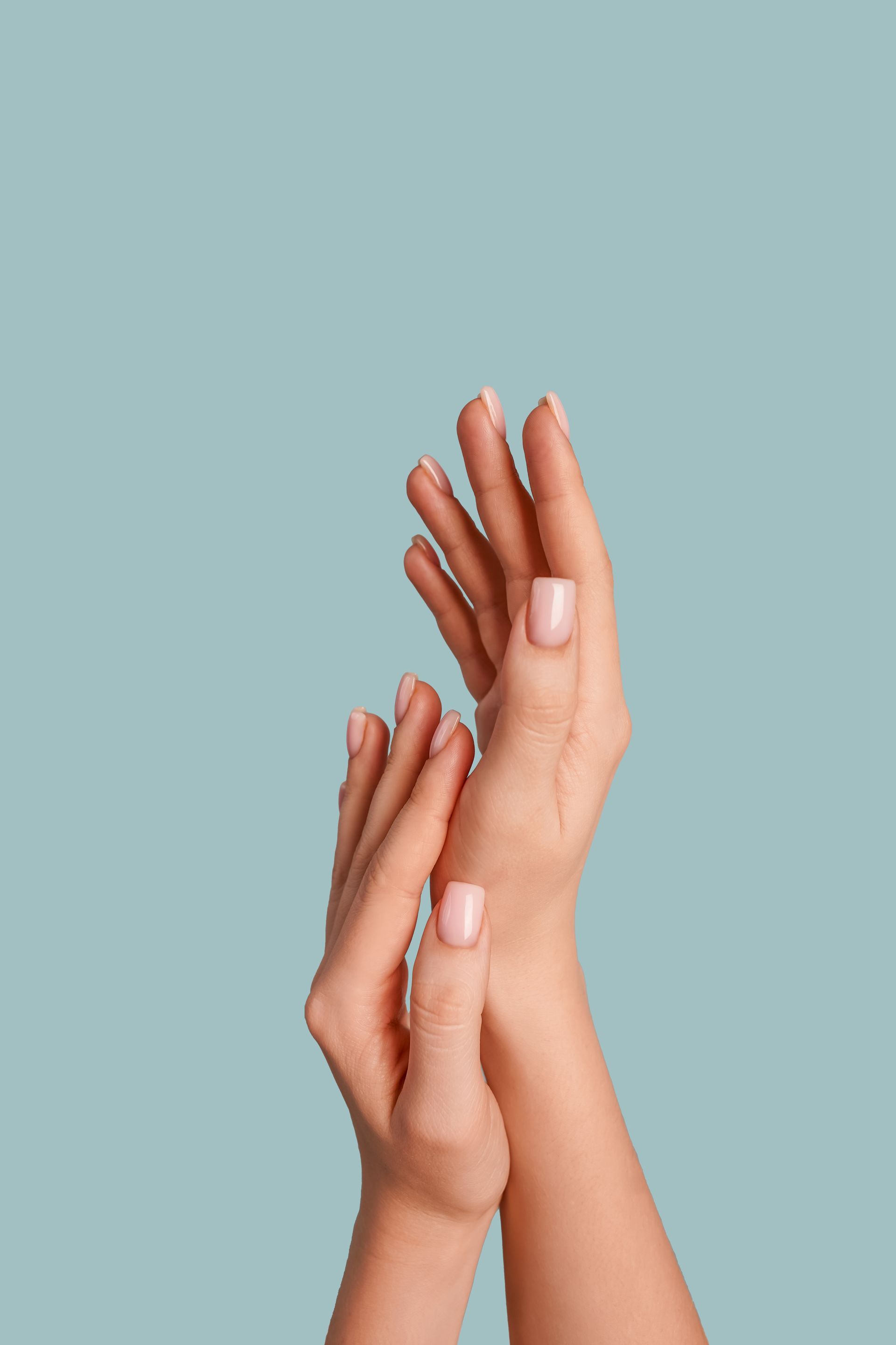 Un primo piano delle mani di una donna su uno sfondo blu.