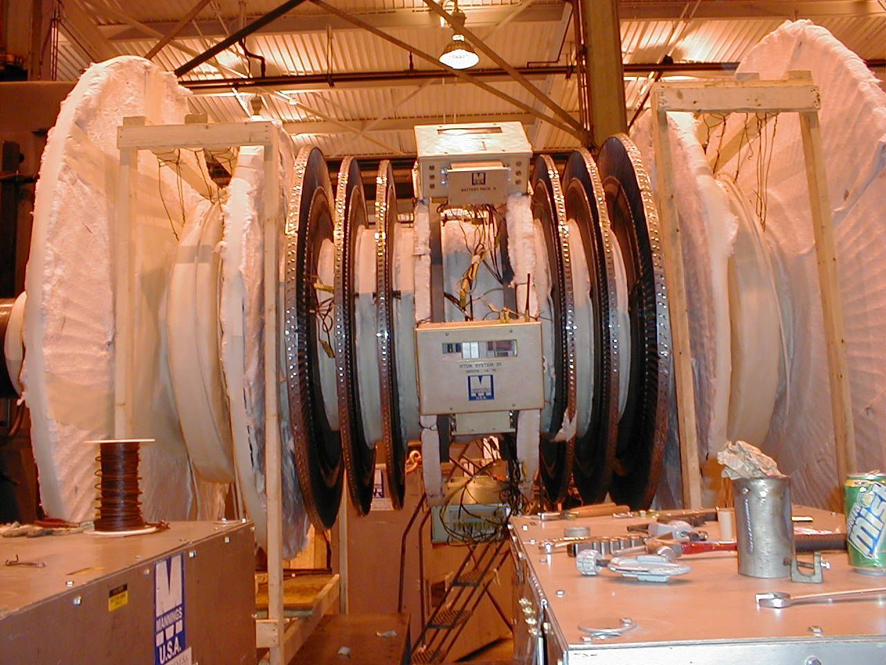 Grande machine industrielle avec de nombreux composants circulaires dans un environnement d'atelier.