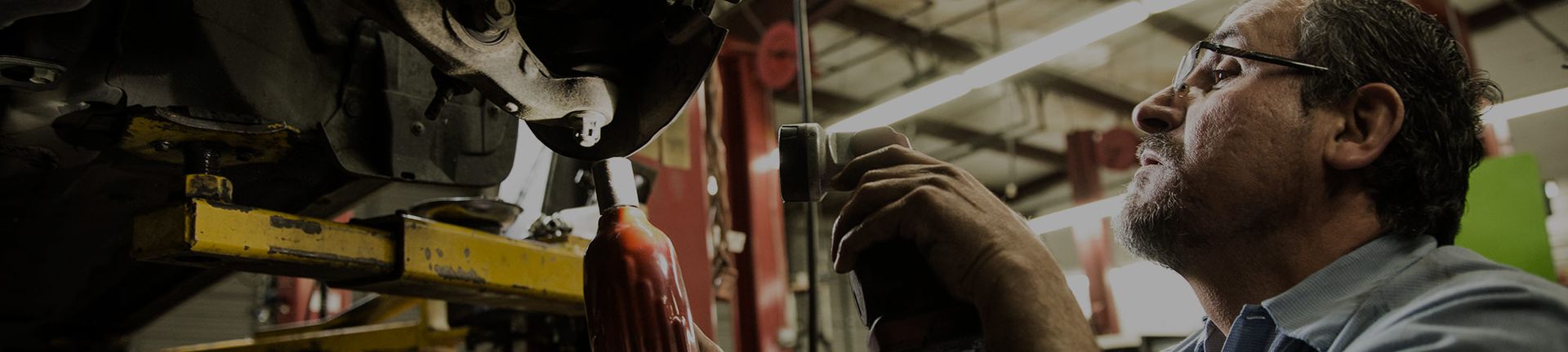 Mechanic Examines the Undercarriage of a Car | Acute Auto Care LLC