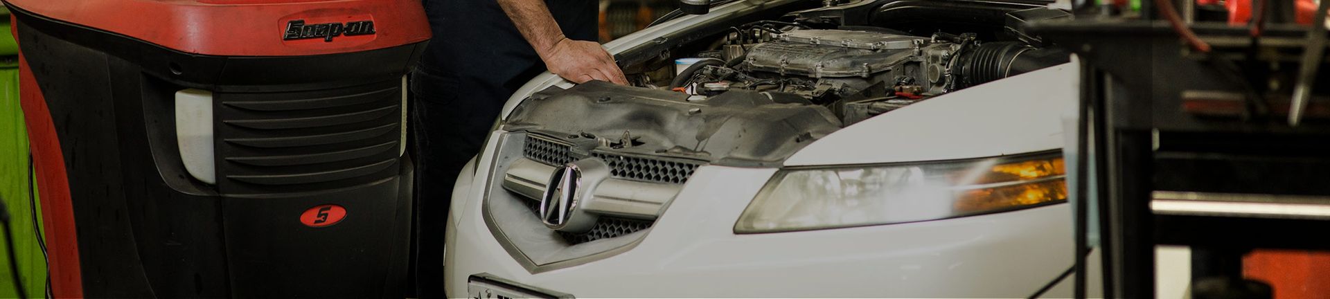 Mechanic Working on a White Car | Acute Auto Care LLC