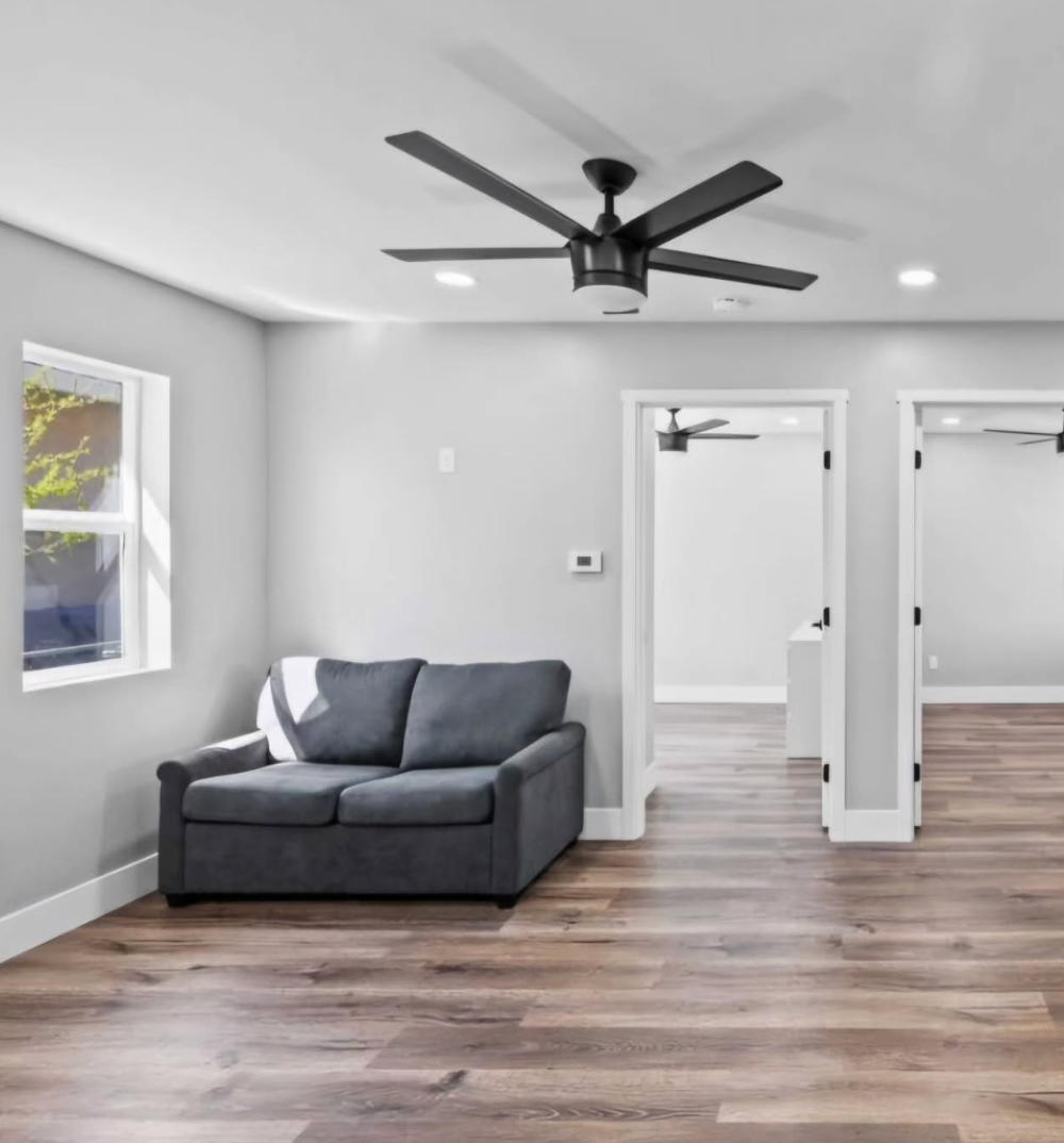 A living room with a couch and a ceiling fan