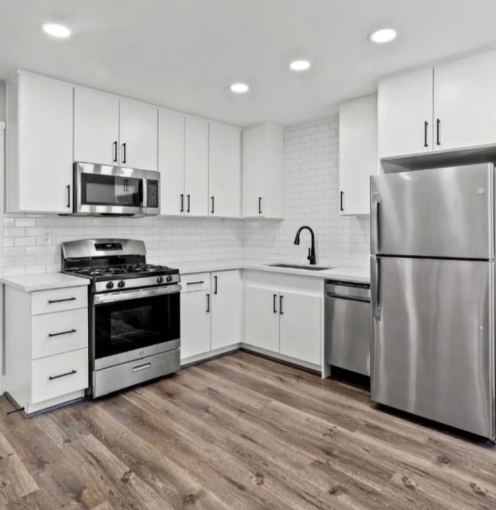 A kitchen with stainless steel appliances and white cabinets