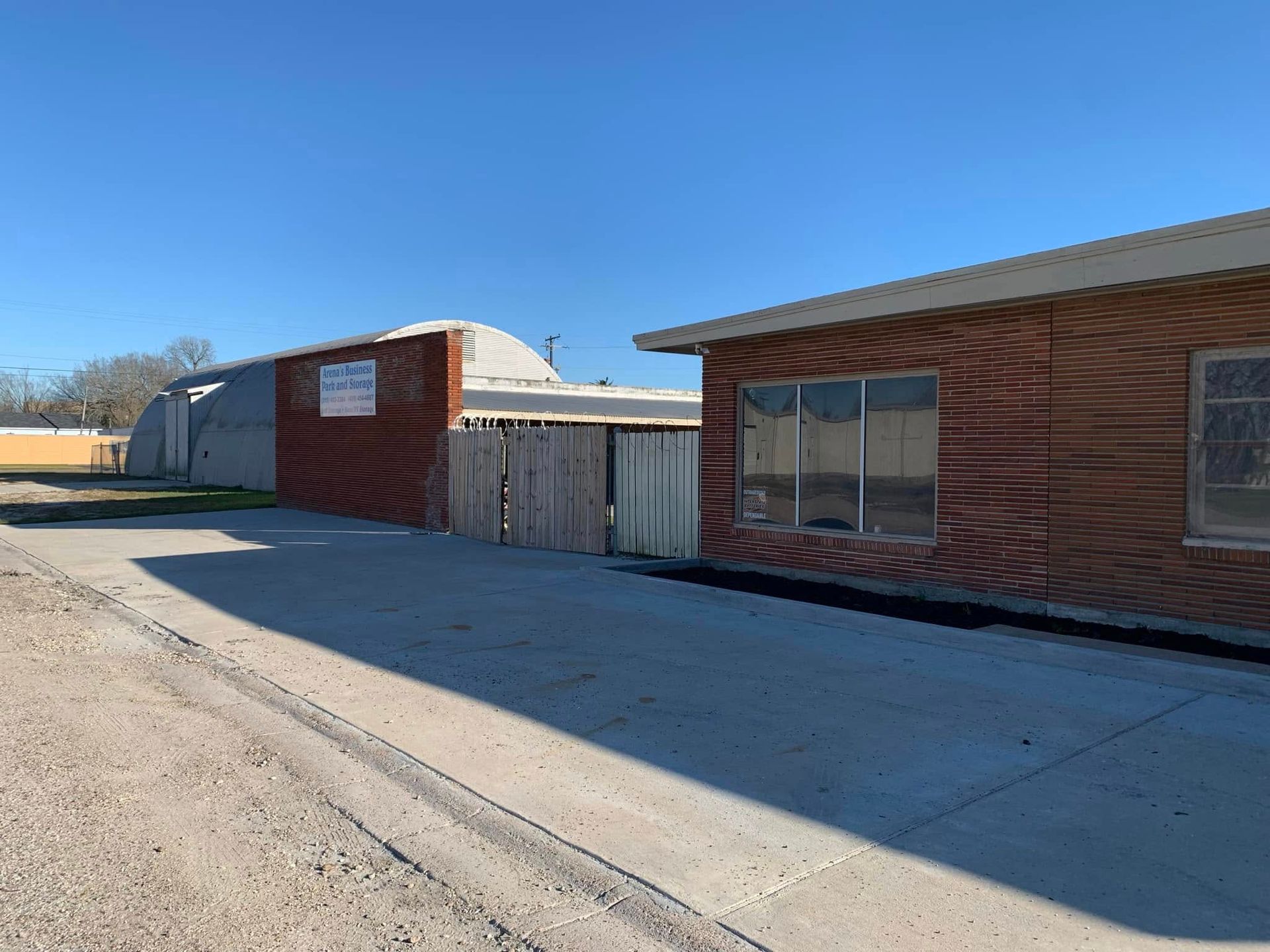 Two brick buildings are sitting next to each other on a dirt road.