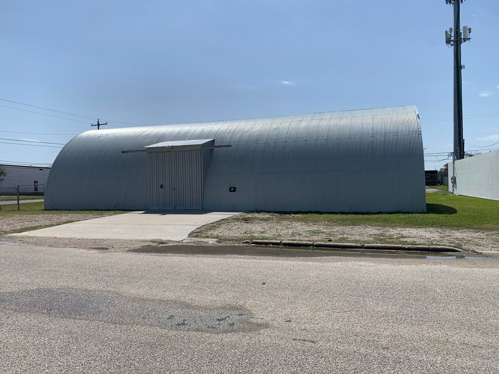 A large gray building is sitting on the side of the road.