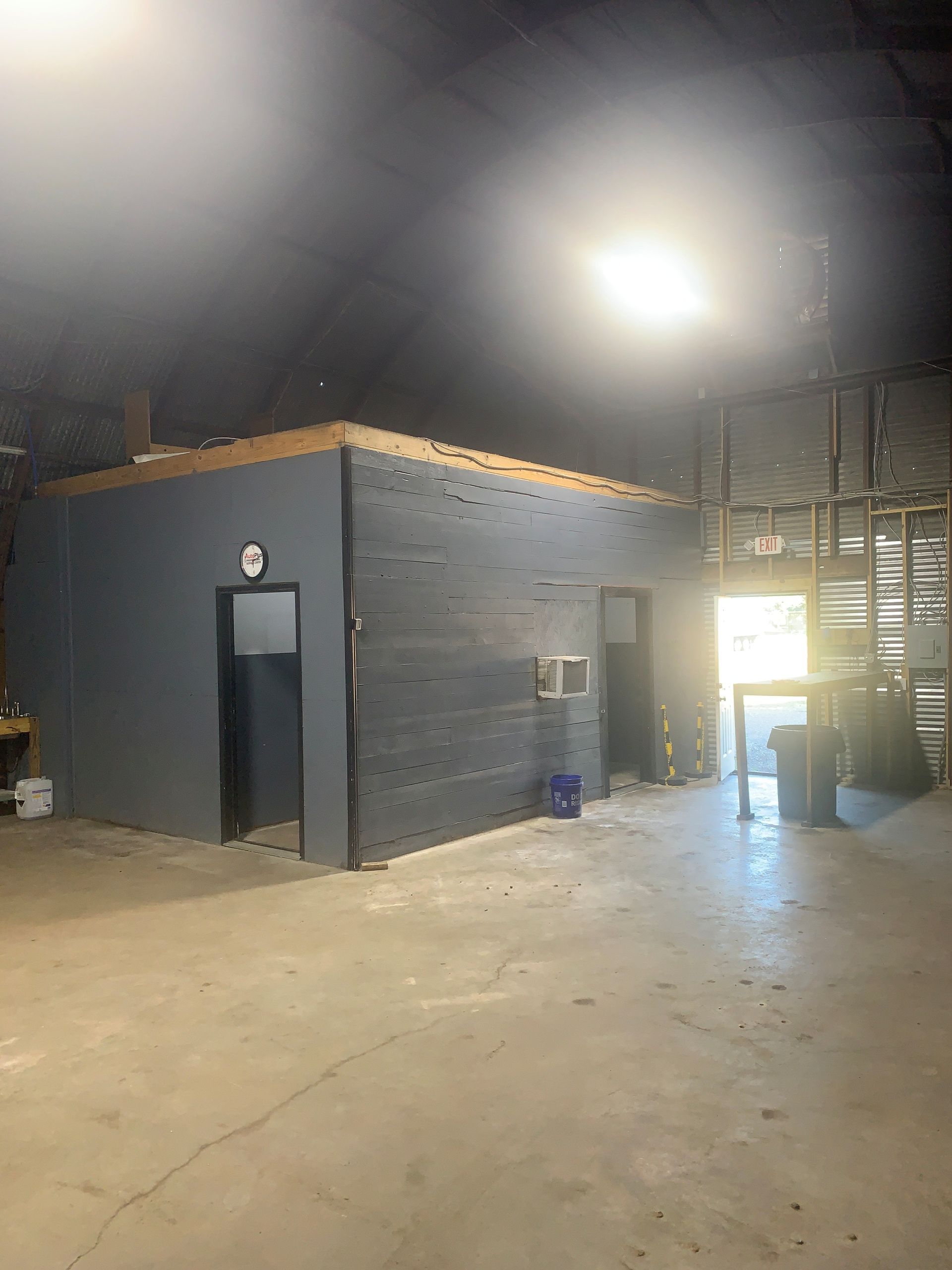 A large empty warehouse with a clock on the wall.