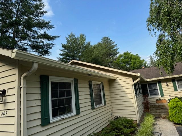 A porch with gutter from the roof of a house.