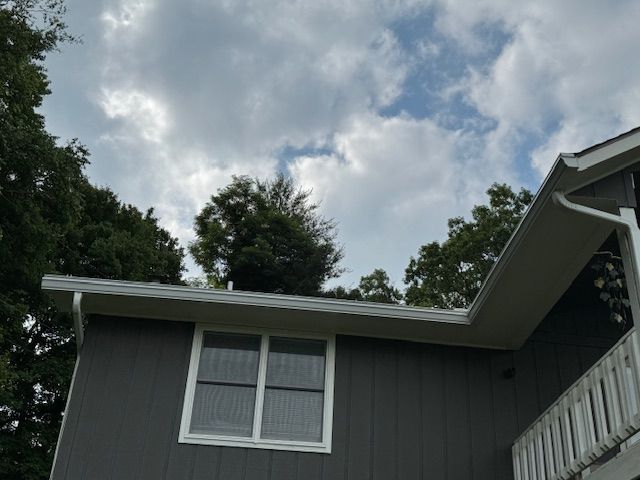 A porch with gutter from the roof of a house.