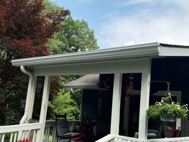 A porch with gutter from the roof of a house.
