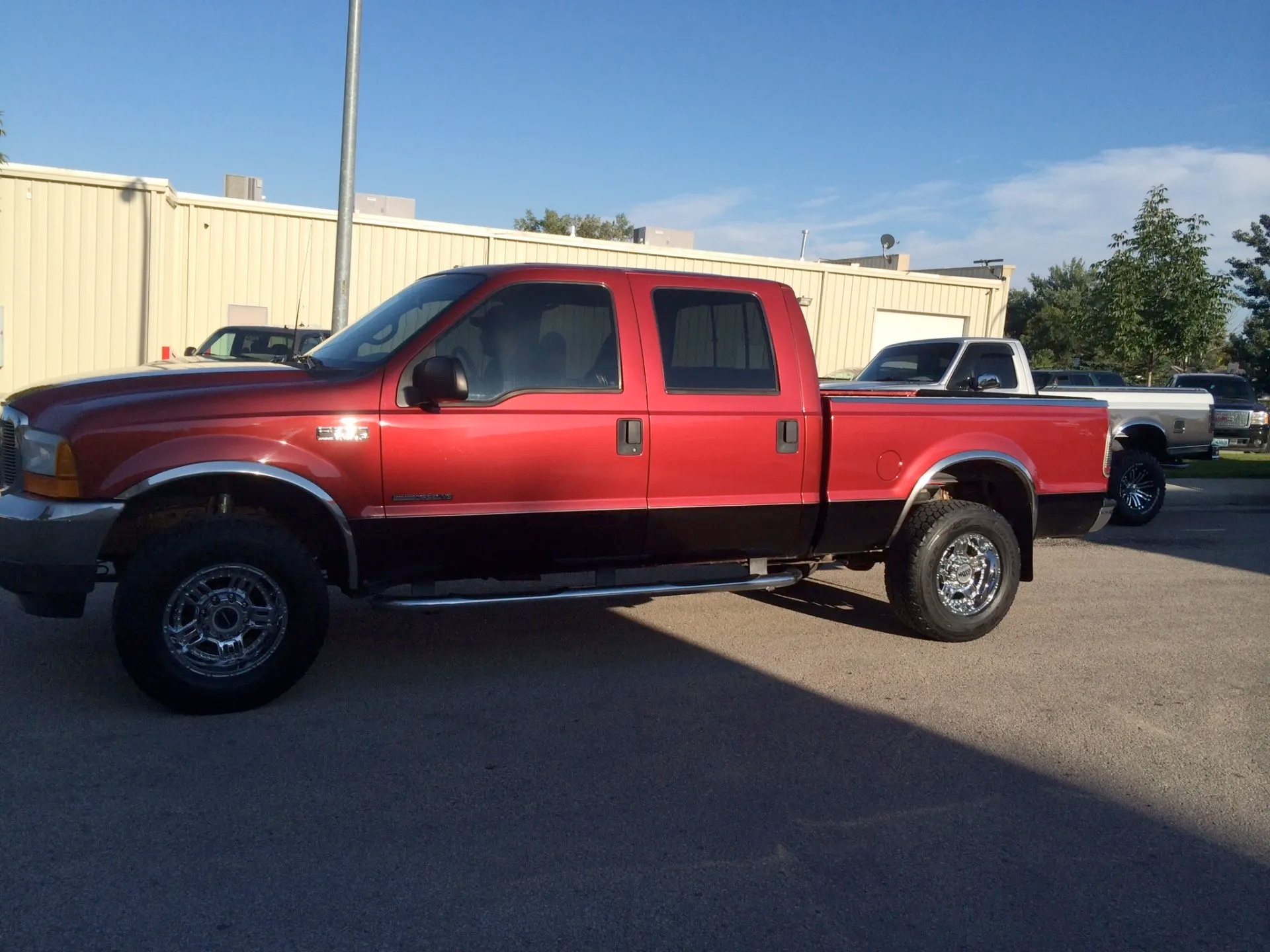 A red truck is parked in front of a building