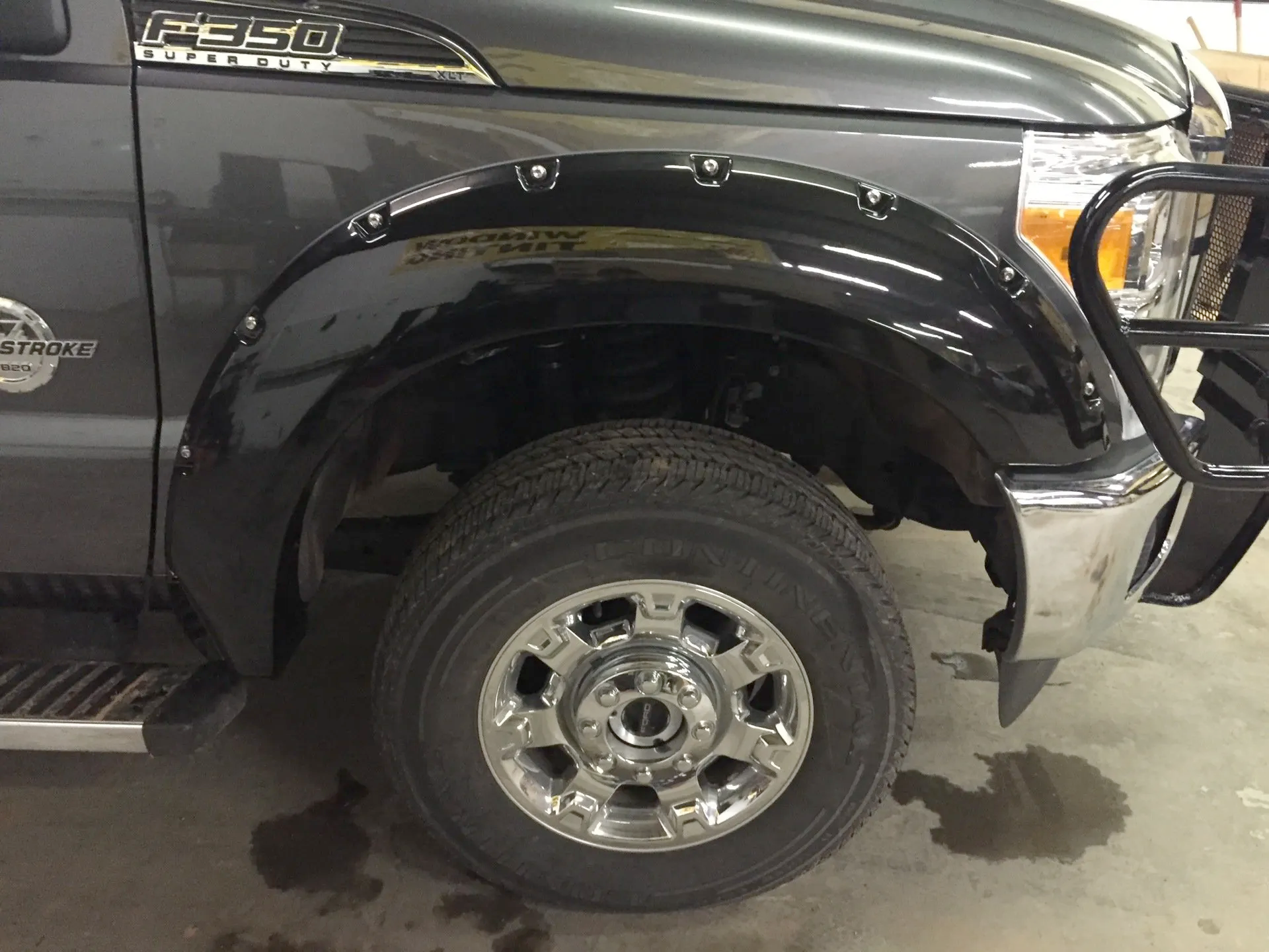 A black ford f250 truck is parked in a garage