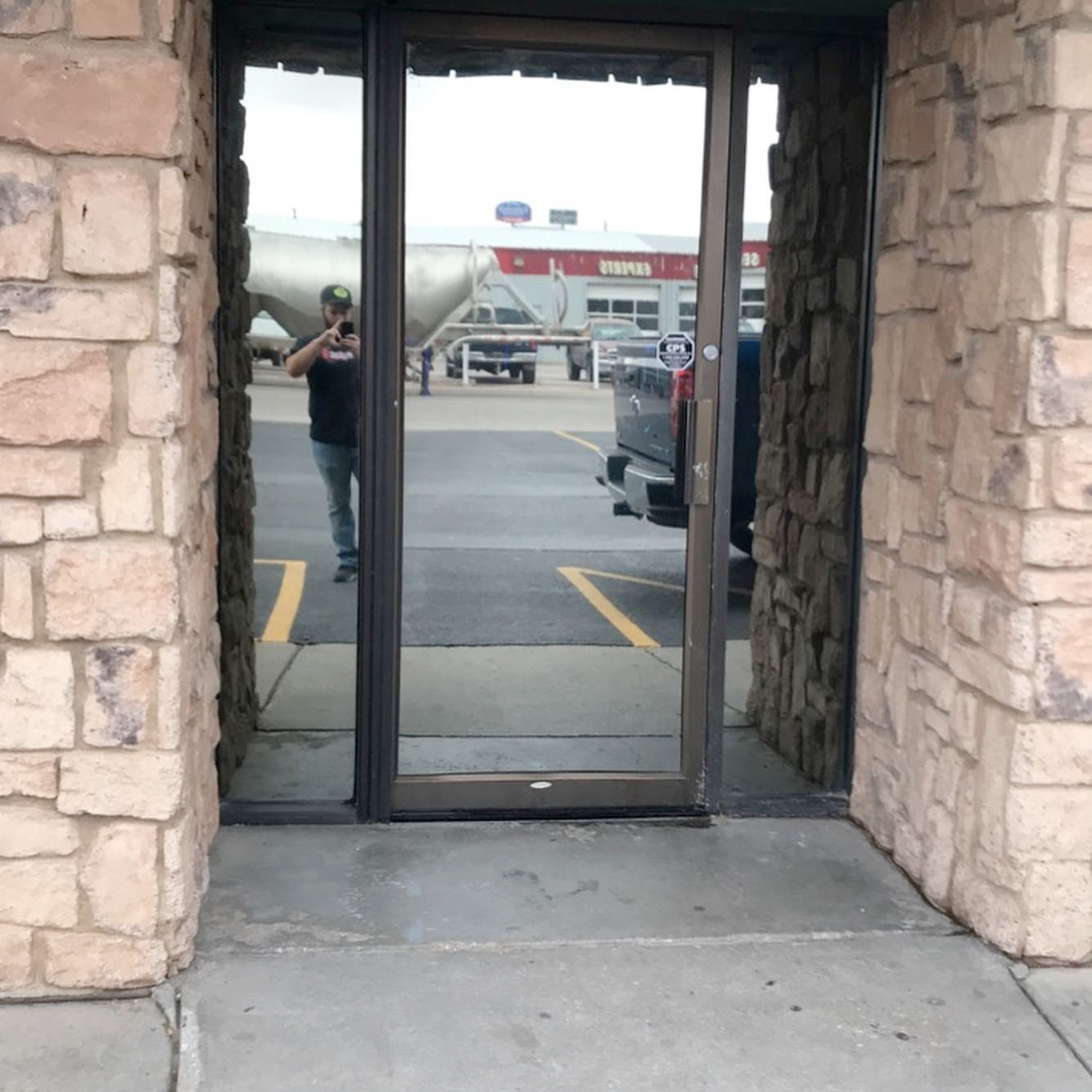 A man is taking a picture through a glass door