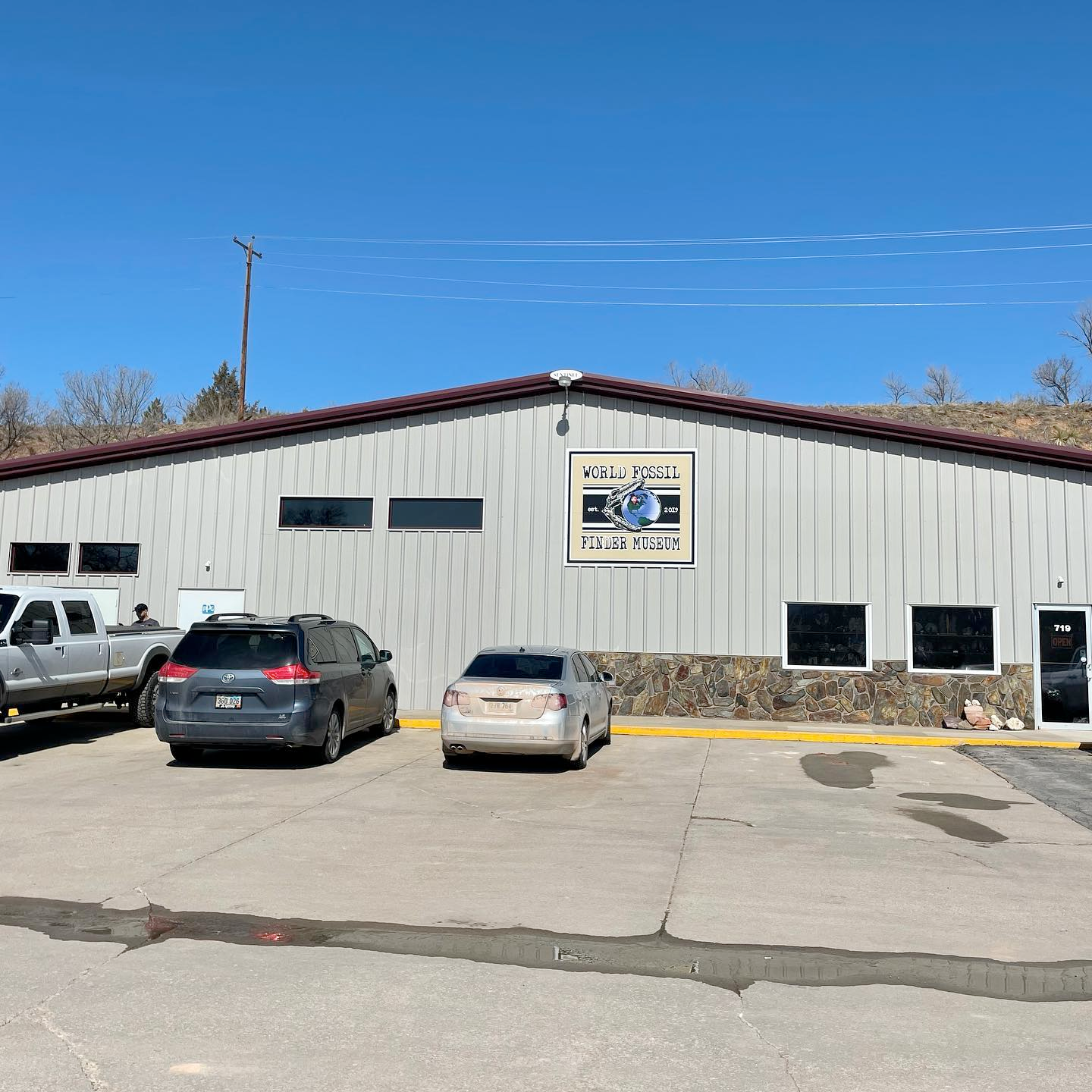 A building with cars parked in front of it and a sign on the side