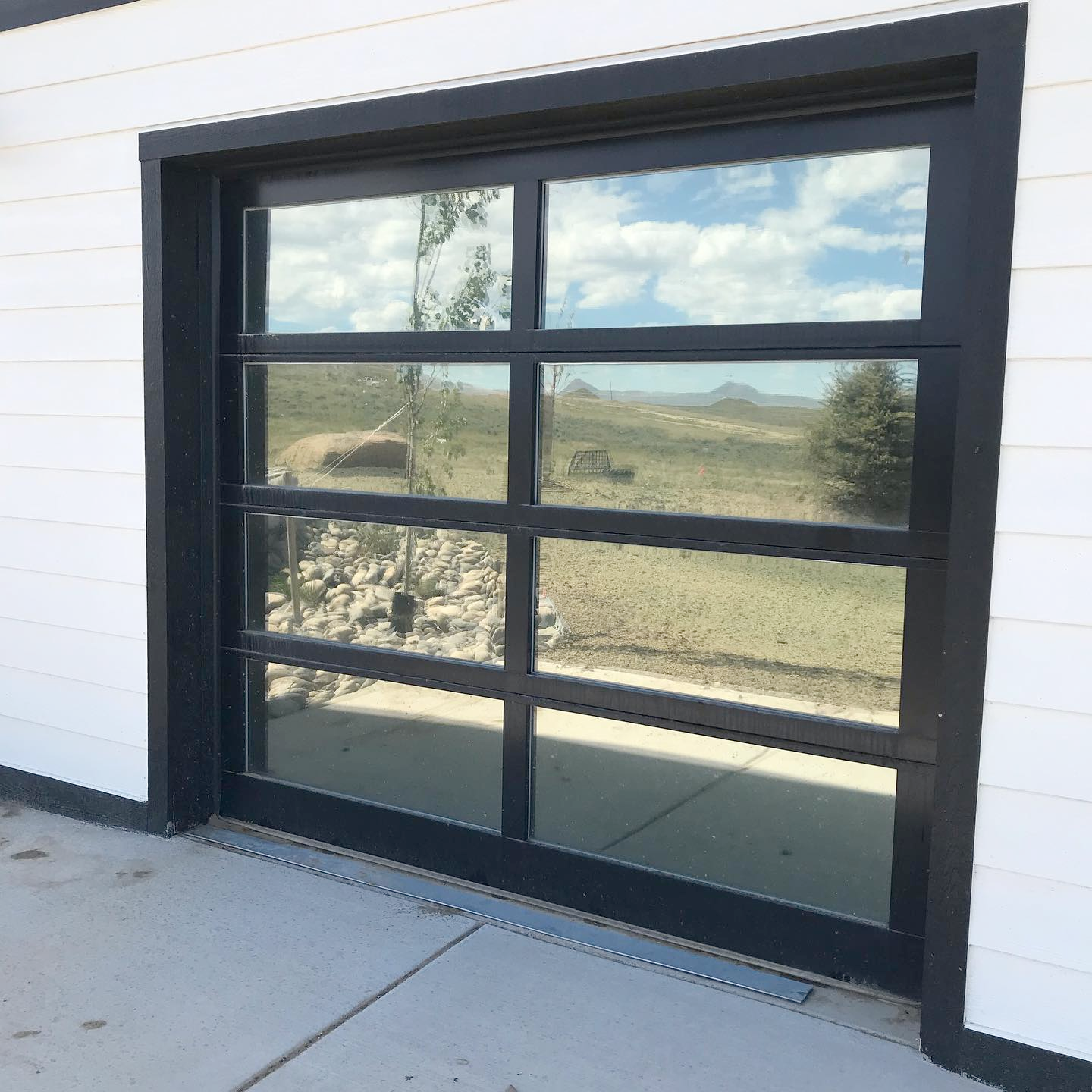 A garage door with a reflection of a landscape in it