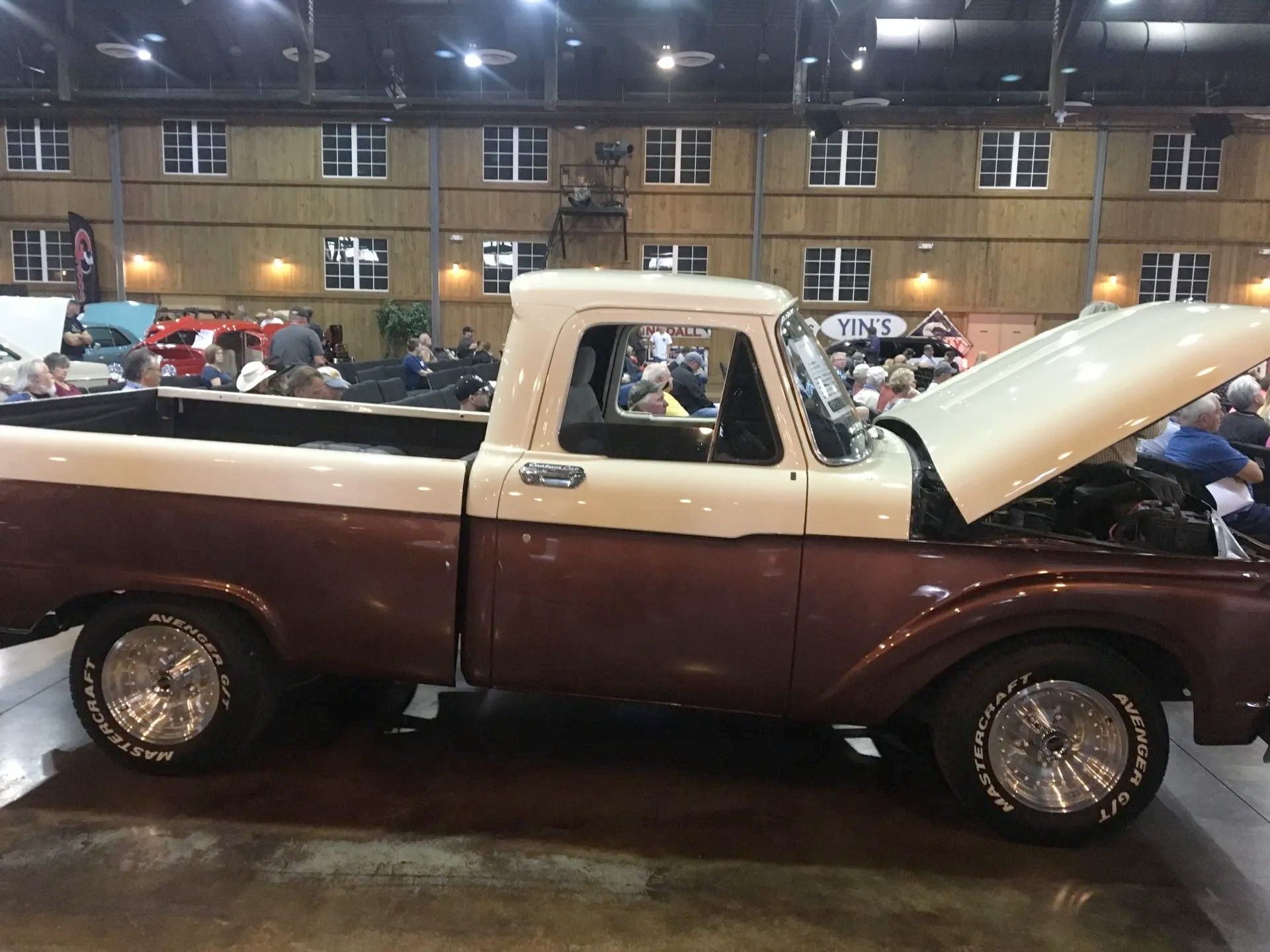 A brown and white pickup truck with the hood open