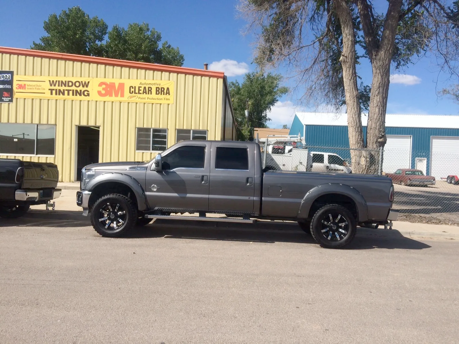 A truck is parked in front of a building that says window tinting