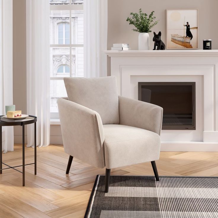Una poltrona beige in un soggiorno con camino e un tavolino laterale.
