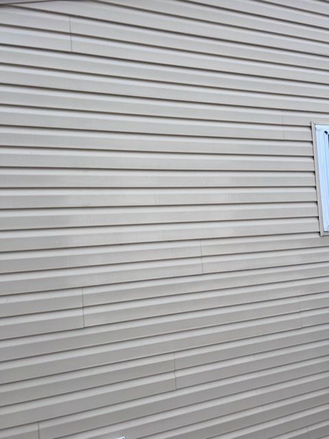 Beige horizontal vinyl siding on a building exterior.