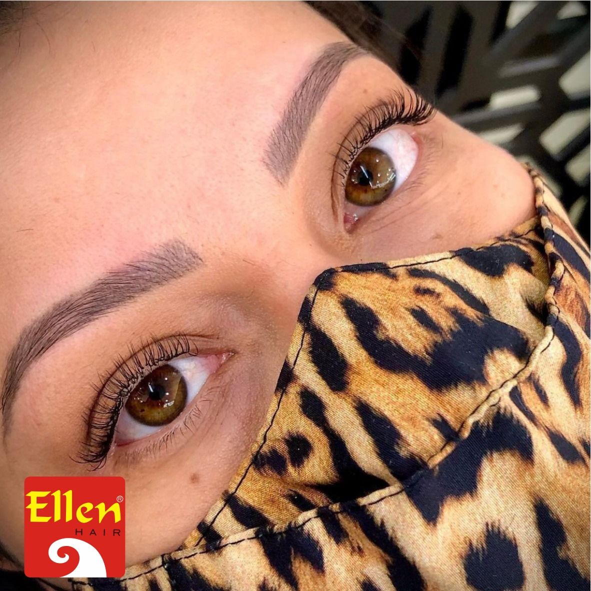 Close de uma pessoa com olhos e sobrancelhas castanhos. Ela usa uma máscara com estampa de oncinha.