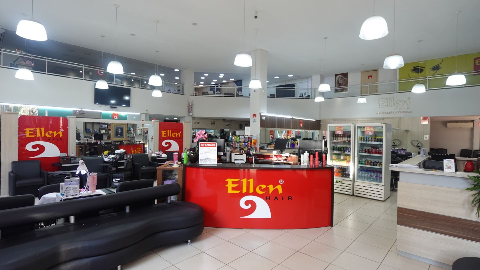 Interior do salão da Ellen Hair com fileiras de cadeiras, espelhos e estações de trabalho bem iluminado.