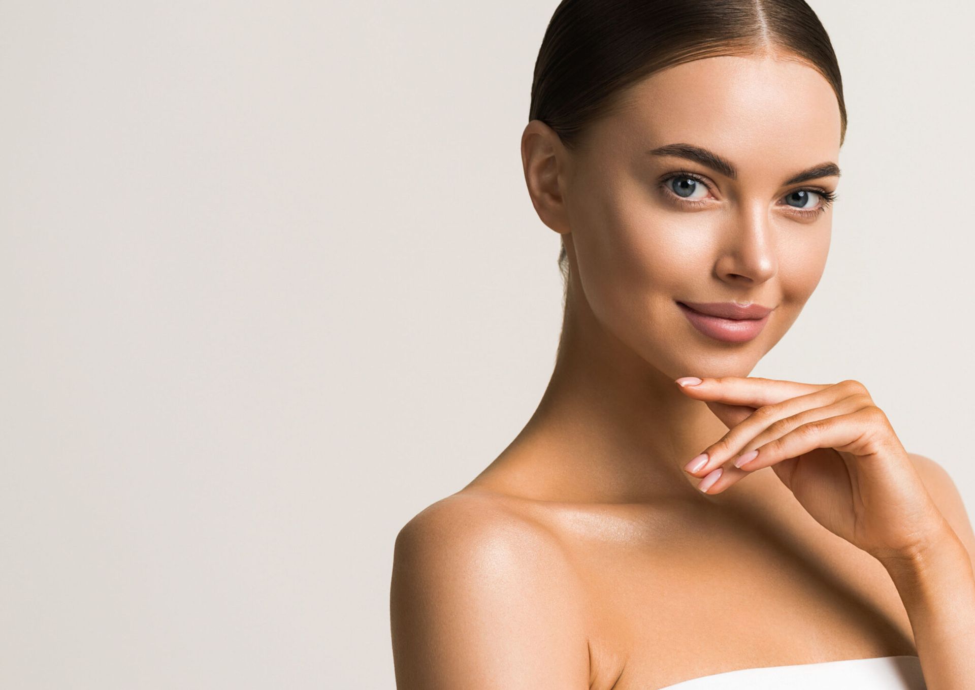 A close up of a woman 's face with her hand on her chin.