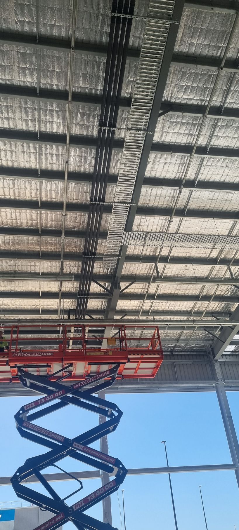 A scissor lift is hanging from the ceiling of a building.