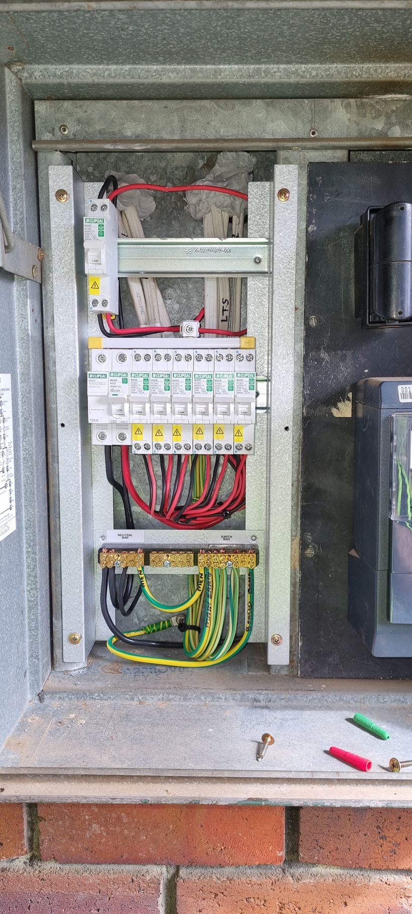 A close up of a electrical box on a brick wall.