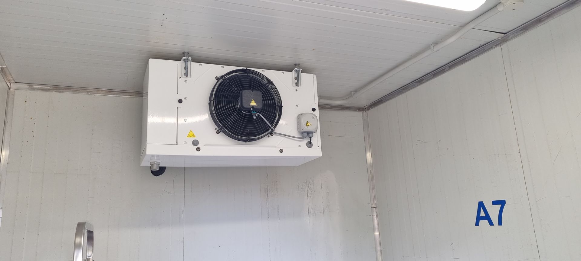 There is a fan hanging from the ceiling of a room.