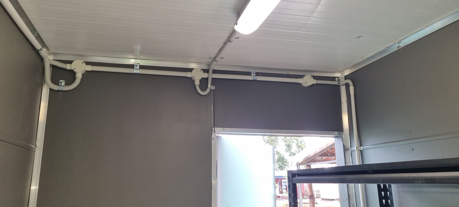 A room with a door and a light on the ceiling.