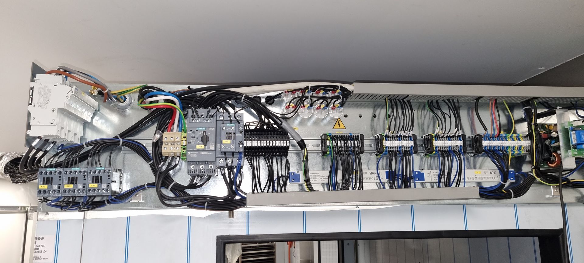 A bunch of wires are hanging from the ceiling of a building.