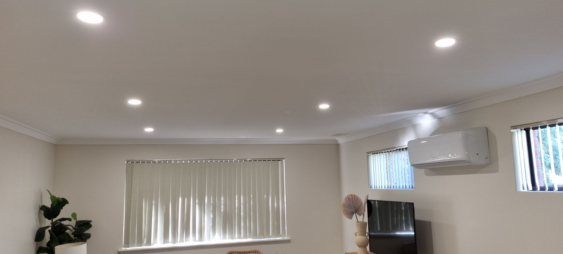 A living room with a ceiling fan and a window.