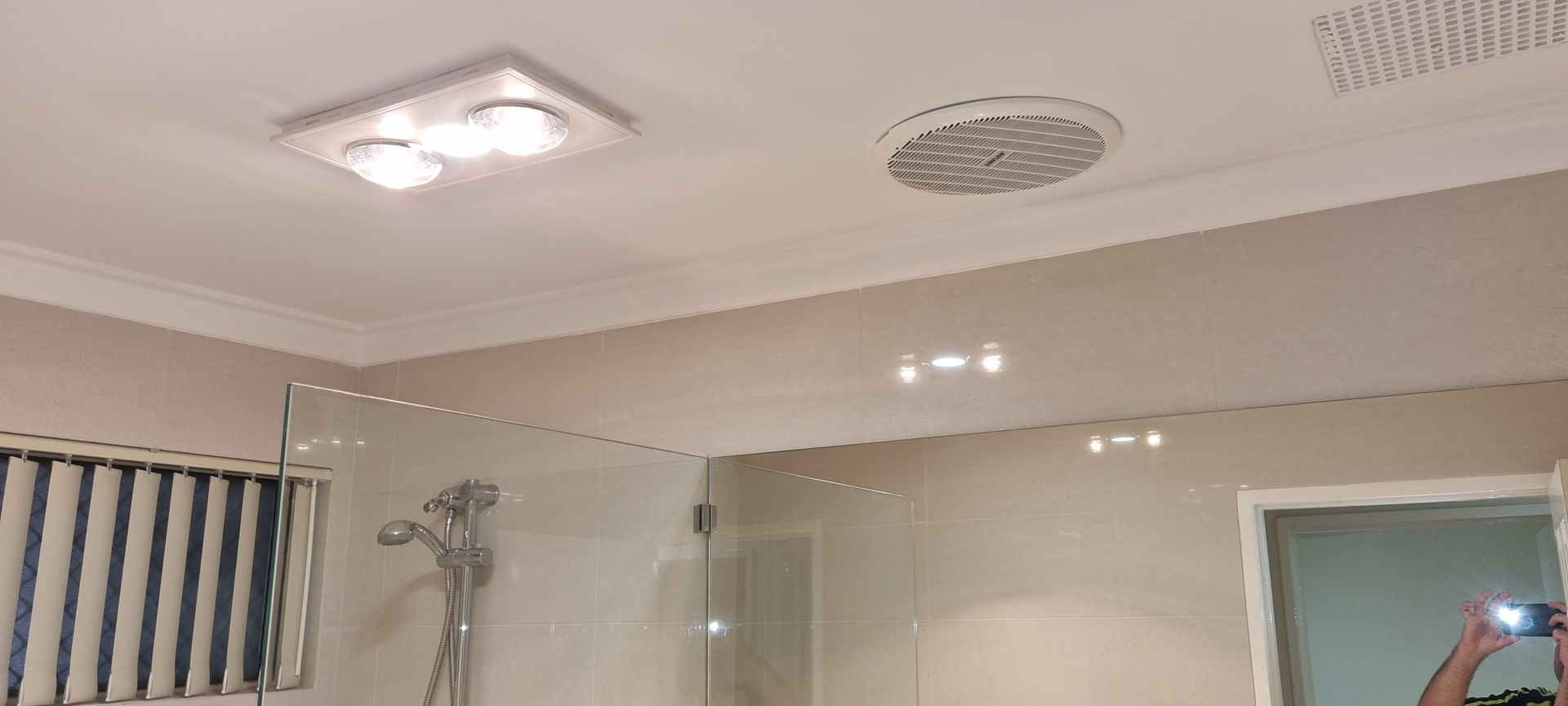 A person is taking a picture of their reflection in a bathroom mirror.