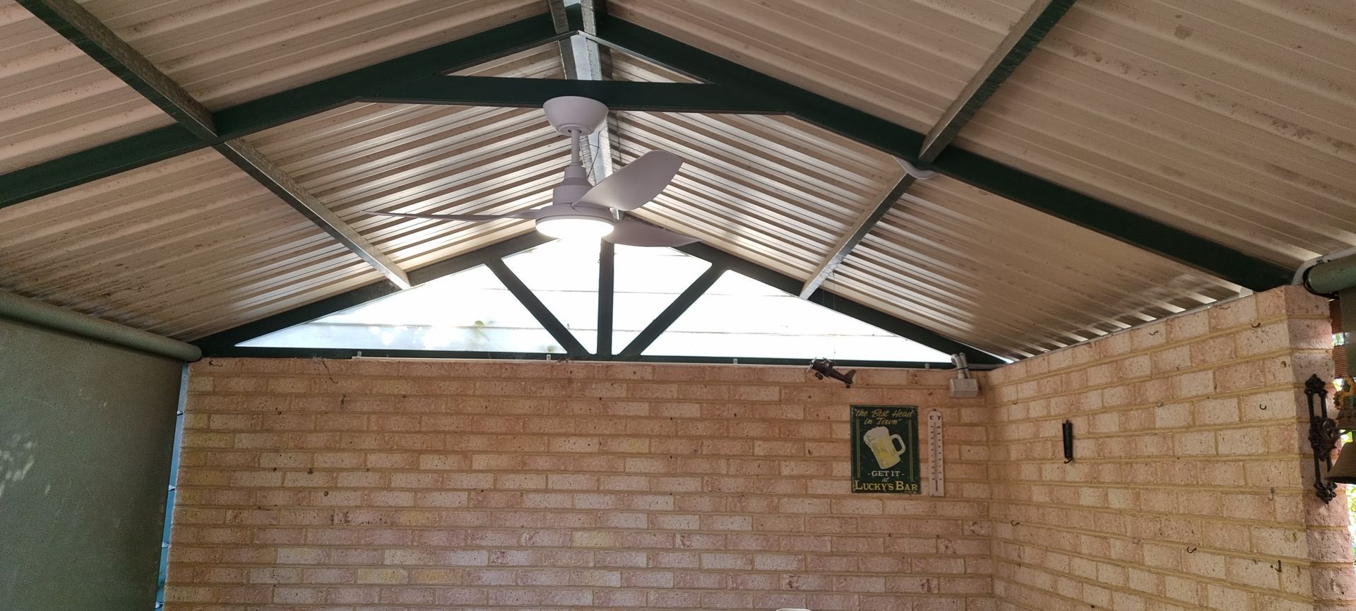 A ceiling fan is hanging from the ceiling of a brick building.