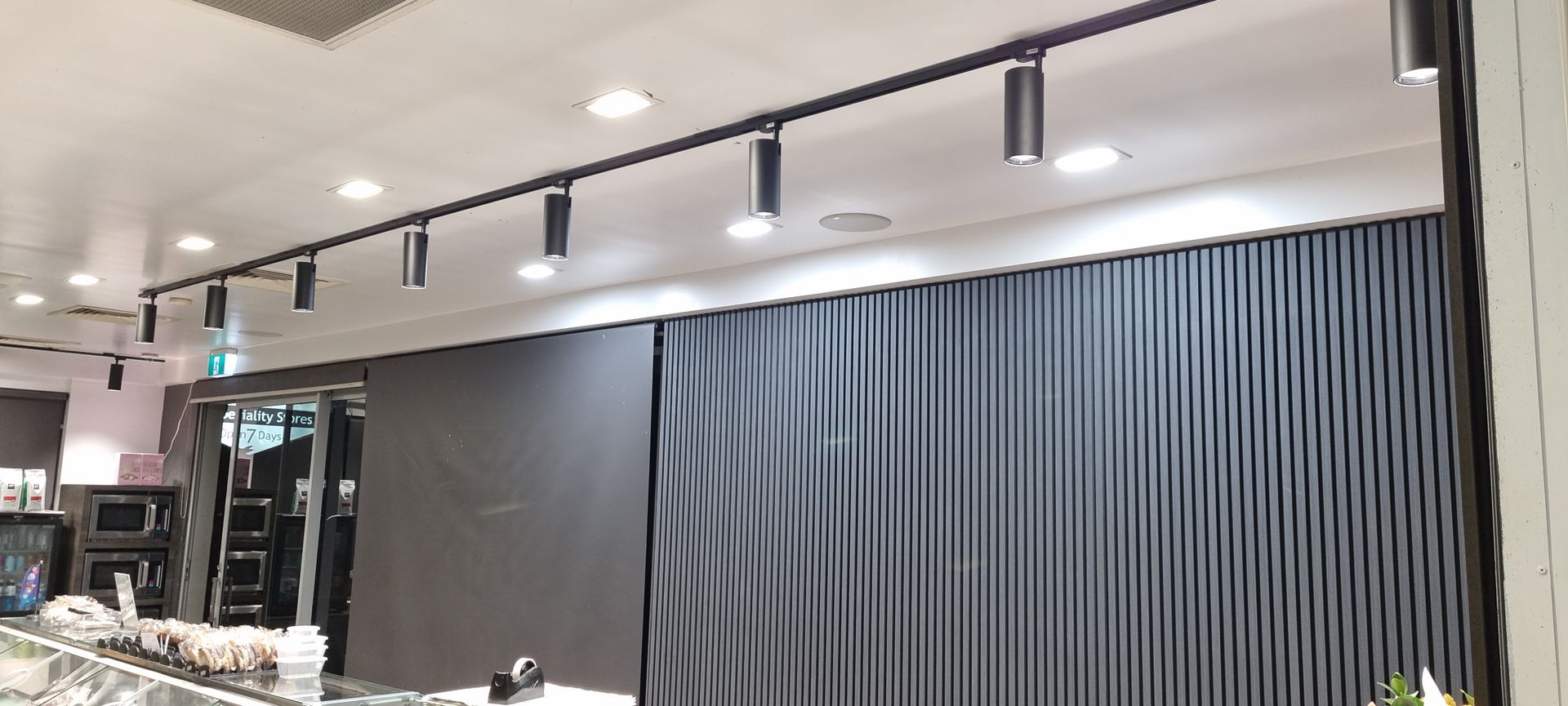 A restaurant with a lot of lights on the ceiling and curtains on the wall.