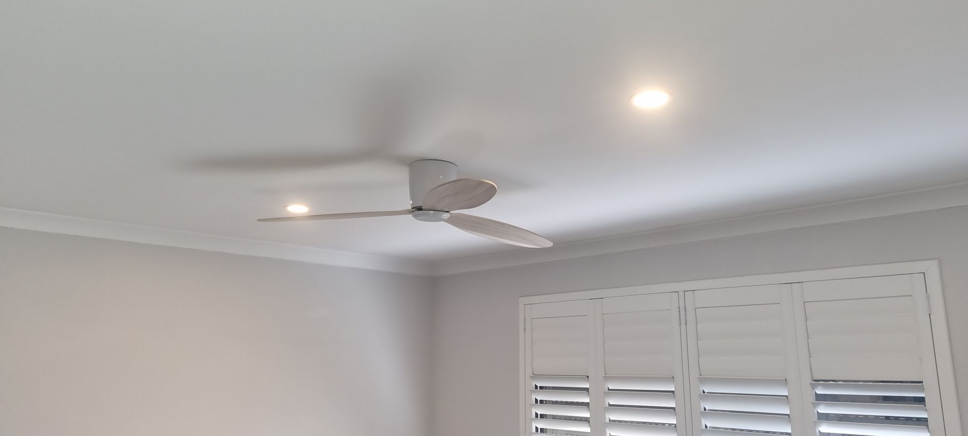 A ceiling fan is hanging from the ceiling of a room.