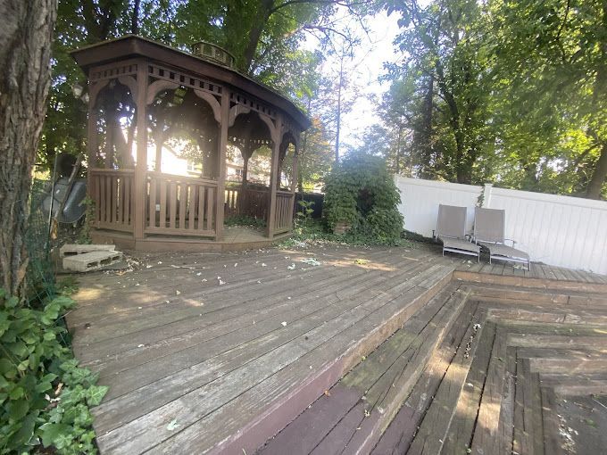 A wooden gazebo is sitting on top of a wooden deck.