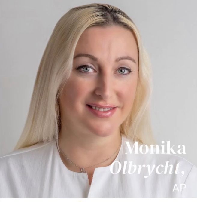Monika Olbrycht, AP, blonde woman with fair skin, smiles, white top, light background.